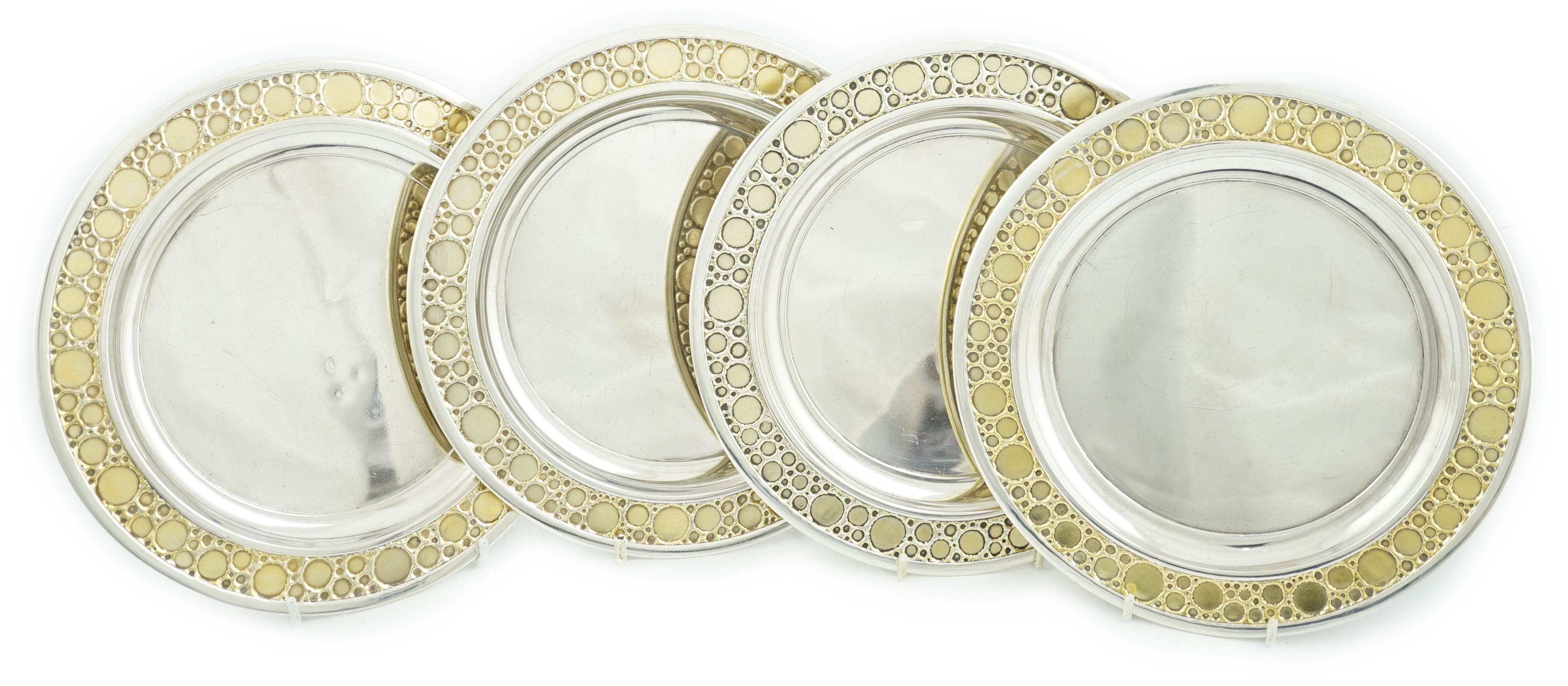 A set of four Elizabeth II Stuart Devlin parcel gilt silver circular plates